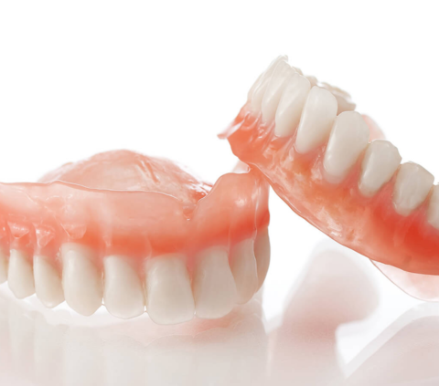 a set of dentures one leaning on the other