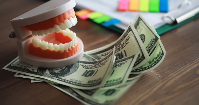 a teeth model with money under the teeth
