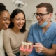 Close-up of a diverse group of people in a dental office, smiling and engaged in a discussion about dental implant options with a friendly dentist.