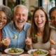 Image of a diverse group of people happily eating and smiling, showcasing the life-changing benefits of affordable dental implants. No text on image.