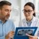 A close-up shot of a patient and dentist discussing the patient's dental records during a consultation in a modern, well-lit dental office.